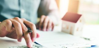 Where to Find Mobile Home Loans and Lenders Home agents are using a calculator to calculate the loan period each month for the customer.